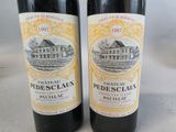 two bottles of red wine sitting next to each other on a table