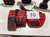 a red corded driller and two other tools on a table