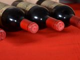 several bottles of wine are lined up on a red table