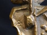 a gold sculpture of a face on a black background
