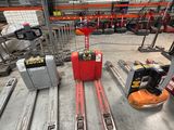 several skis are lined up in a warehouse with a fork lifter