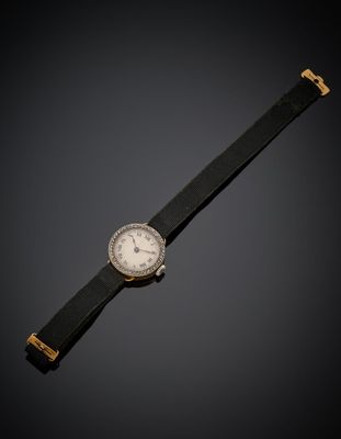une vieille montre posée sur une surface noire, avec un fond noir