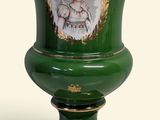 un vase vert orné d'une image représentant une femme