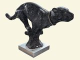 statue of a dog on a pedestal with a chain around its neck