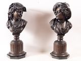 pair of bronze busts of a woman and a man on pedestals
