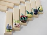 a picture of a row of pops with fruit and flowers on them