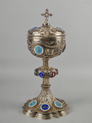un calice argenté et bleu surmonté d'une croix