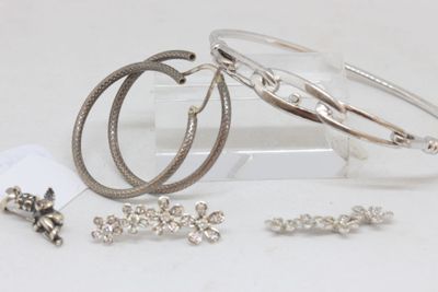 three bracelets and a pair of earrings sitting on a table