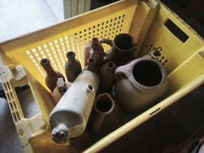 a yellow basket filled with vases and bottles