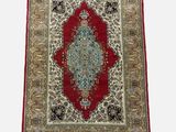 a red and blue rug with a medallion design on a white background