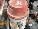 un aspirateur rouge et blanc posé par terre