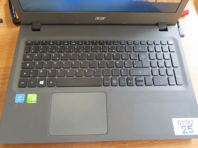 un ordinateur portable posé sur une table, sur lequel est collé un autocollant