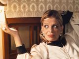a woman that is sitting in a bed with a lamp