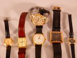plusieurs types de montres sont alignés sur une surface blanche
