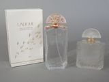 an image of a bottle of perfume next to a box on a table