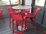 an image of a patio with red chairs and a table