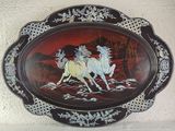 a decorative plate with a painting of two horses on it