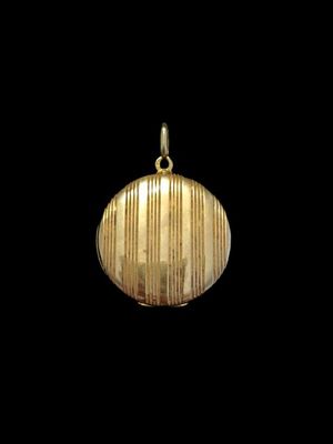 une image représentant un pendentif en or suspendu à une chaîne, sur fond noir
