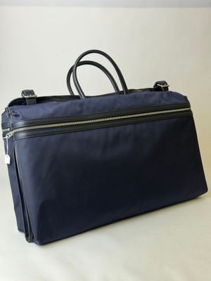 une image représentant un sac bleu posé sur une surface blanche
