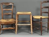 trois chaises en bois sont alignées contre un mur gris