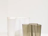 three different colored cups sitting on top of a white table