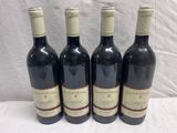 quatre bouteilles de vin sont alignées sur une table