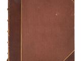an old book with a brown cover sitting on top of a white surface