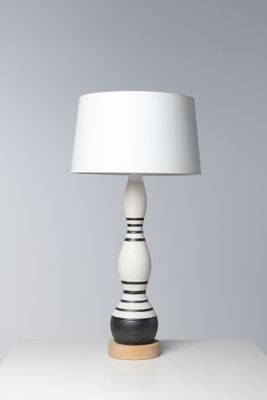 une lampe de table blanche avec un pied noir et un abat-jour blanc