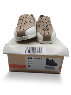 une paire de chaussures dans une boîte posée sur une surface blanche, avec un code-barres