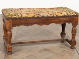 un banc en bois avec une assise rembourrée à motifs floraux