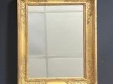 an image of a gold framed mirror hanging on a black wall