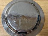 a silver plate on a wooden table with a silver lid