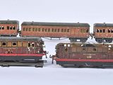 plusieurs petits trains sont alignés sur une surface blanche