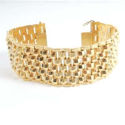a close up of a gold bracelet on a white background