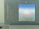 une photo d'un tableau accroché au mur à côté d'un banc
