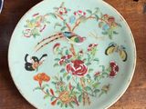 a plate with flowers and birds on it on a table
