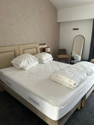 un lit avec deux oreillers et un miroir dans la chambre