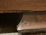 a close up of a wooden bench with a hole in it