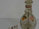 a glass bottle with toothbrushes and toothpaste in it