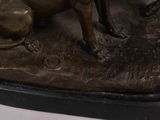 bronze statue of a dog and a cat on a rock
