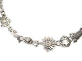 an image of a silver necklace with animals and flowers on it