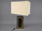 a black and gold table lamp with a white shade on it