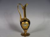 a gold vase with a black and white design on it