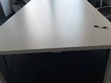 une table blanche sur laquelle se trouve un stylo, dans une pièce