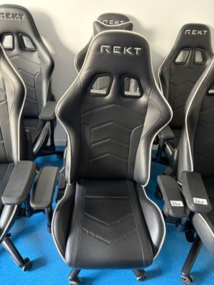 quatre sièges de course noirs et blancs posés sur un tapis bleu