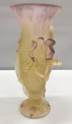 a glass vase with a bird on it sitting on a table