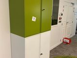 a green and white cabinet in a room with a green rug