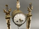 a clock that is sitting on top of a marble stand