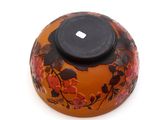 an orange vase with a black lid on a white surface