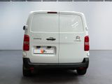 the rear of a white van is parked in a garage